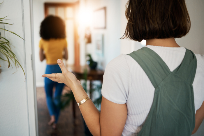 Lgbtq, women and couple with back in conflict, fight or problem in hallway or room of home and frustrated. Lesbian, people and partner with anger or stress in lounge of house for crisis or argument Nicht eheliche Lebensgemeinschaft zerbricht – Fachanwältin für Familienrecht Köln berät.