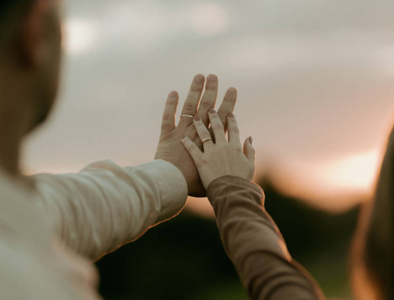 Ehepartner strecken gemeinsam die Hände und berühren sich